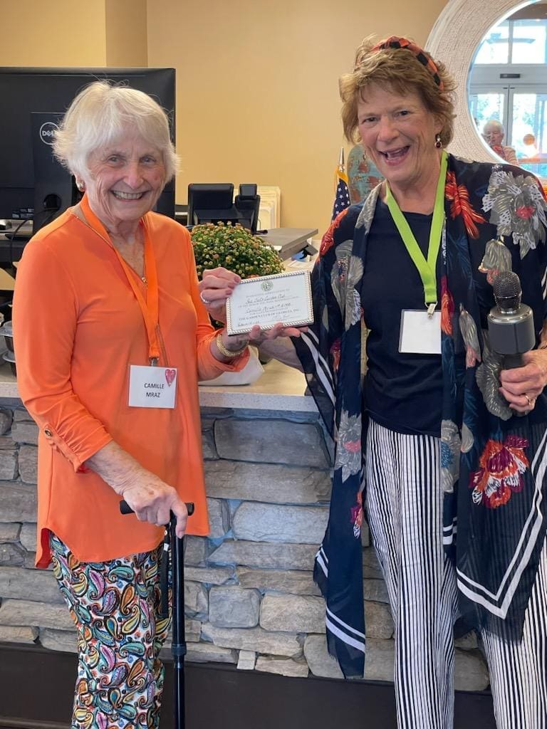 Two women holding a check and smiling.