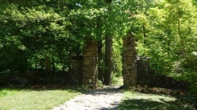 Old stone archway surrounded by green trees.