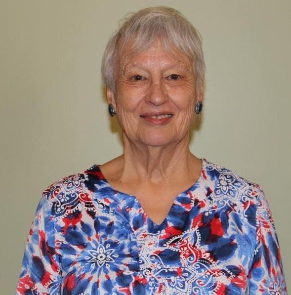Portrait of a smiling elderly woman with short gray hair.