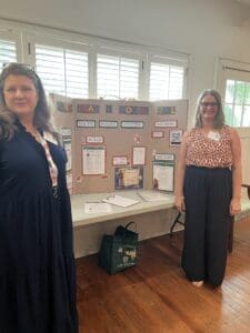 Two women standing by a presentation board.