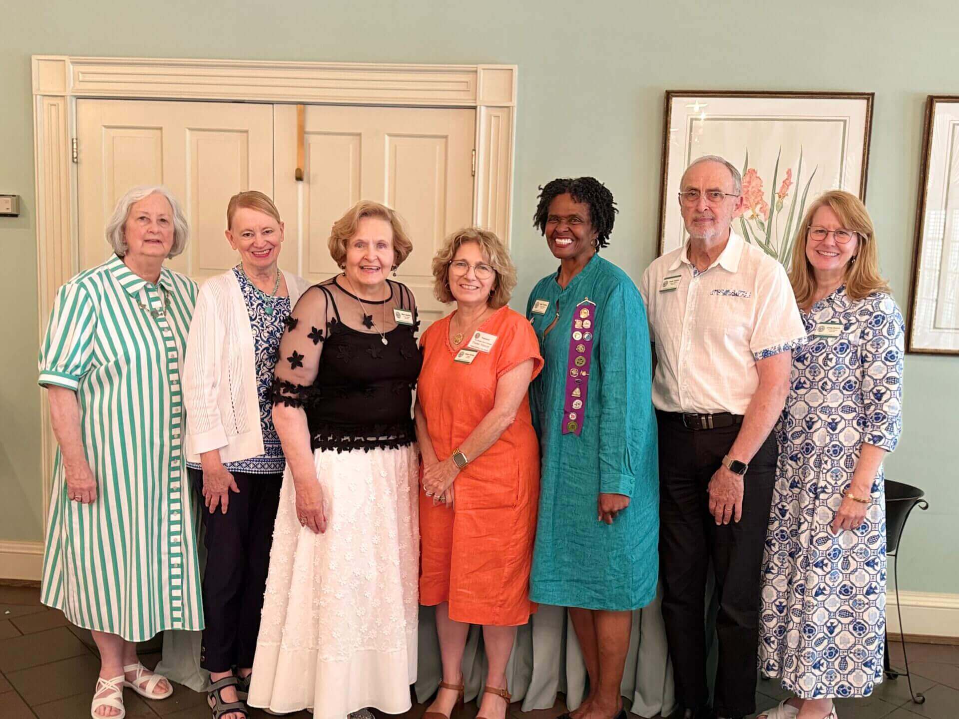 Seven people posing together in a room.