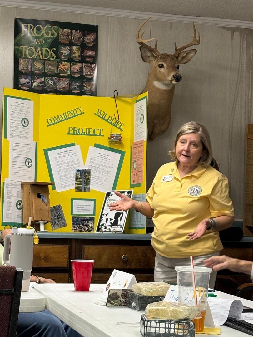 Woman presenting community wildlife project indoors.