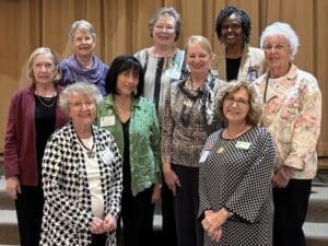 Group of smiling women in formal attire.