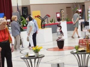 Indoor plant and flower exhibition with attendees.