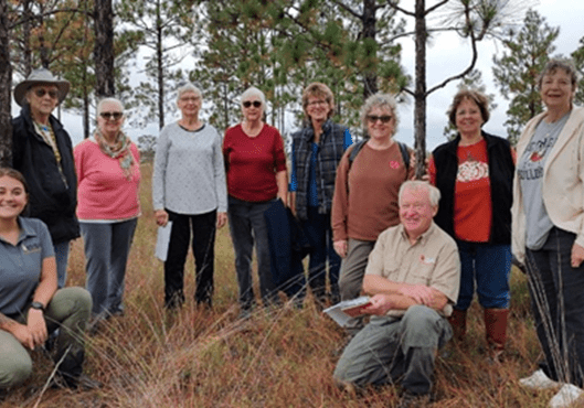 A group of people standing in the grass.